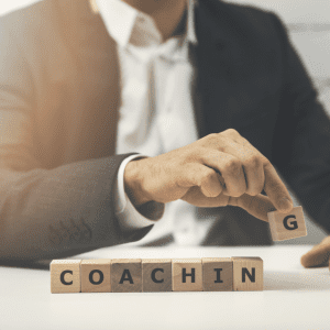 Successful business coach | hand holding wooden blocks that spell out "coaching"