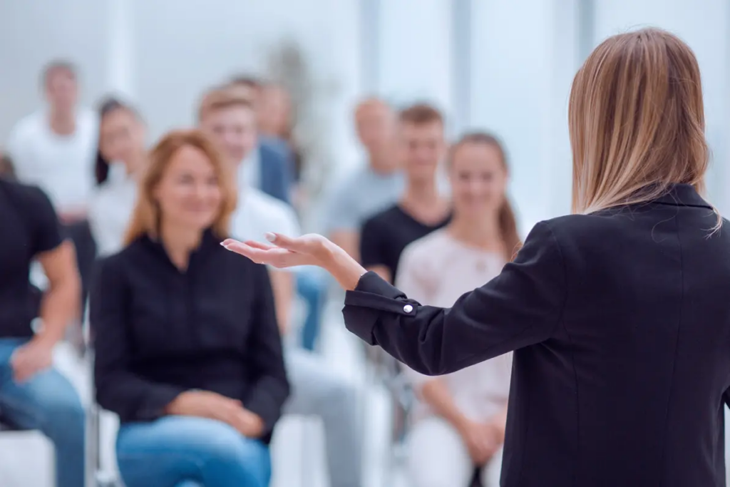 Starting a coaching business | Person talking to a group in a business setting.