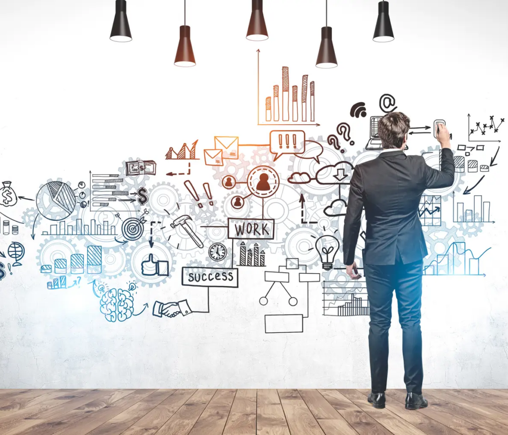 Coaching business | Person in suit drawing on wall, different business-related images like graphs and numbers. 